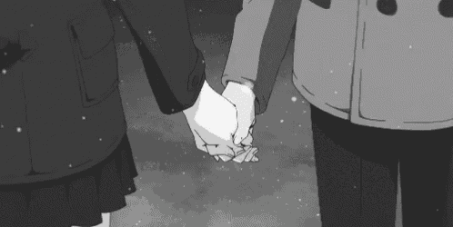 a black and white photo of a couple holding hands in the snow .