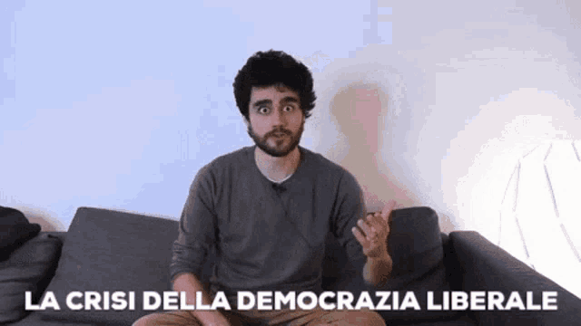 a man sitting on a couch with the words la crisis della democrazia liberale written on the bottom
