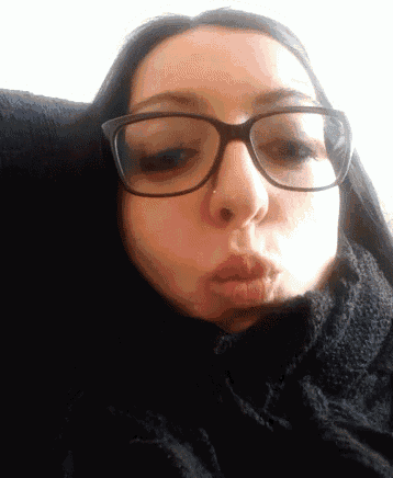a close up of a woman wearing glasses and a black scarf