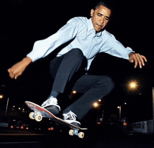 a man in a blue shirt is riding a skateboard on a street at night