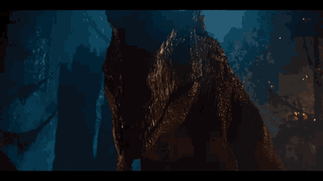 a close up of a t-rex in a dark forest