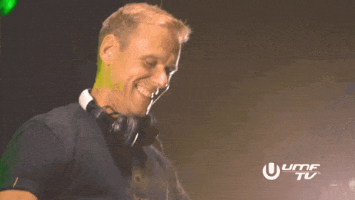 a man wearing headphones is smiling in front of a sign that says umf tu