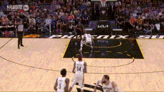 a group of basketball players are playing a game of basketball on a court with a crowd watching .