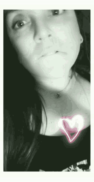 a black and white photo of a woman 's face with a heart on her chest