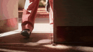 a person 's feet are shown walking through a door