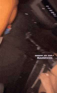 a person is sitting in the back seat of a car with a sticker that says see you soon
