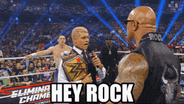 a man in a suit holds a microphone in front of a crowd and says hey rock