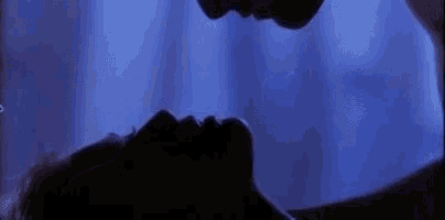 a man and a woman are kissing in the dark in a room .