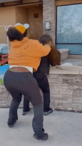 a couple of women are standing next to each other on a sidewalk .