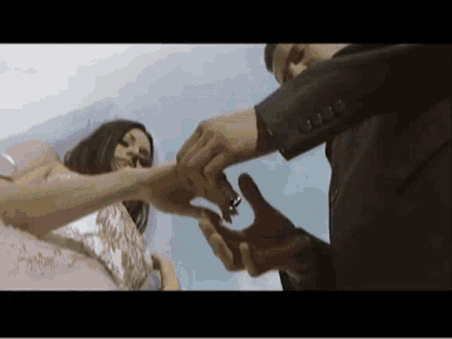 a man putting a ring on a woman 's finger