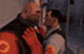 a man in a red vest with the letter o on the back is kissing another man