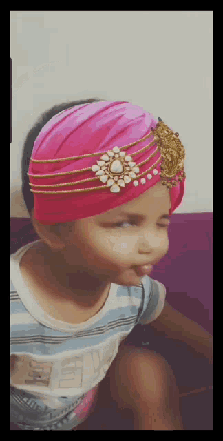 a little girl wearing a pink turban and a shirt that says ' snl ' on it