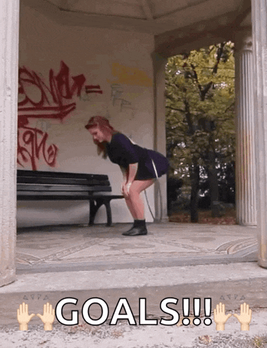 a woman squatting down with the words goals written on the ground