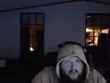 a man with a beard wearing headphones and a hood