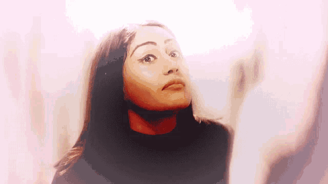 a woman in a black shirt is looking up at something .