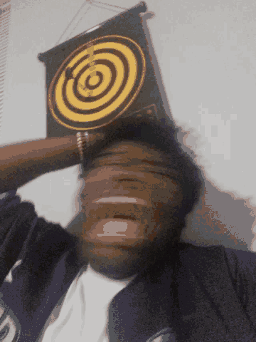 a person laying on their back with a dart board behind them