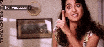 a woman is talking on a cell phone and making a face .