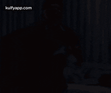 a man in a blue shirt is giving a high five to another man in a hotel room .