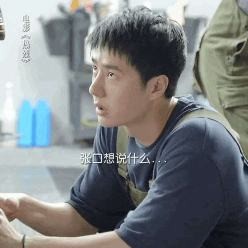 a man in a blue shirt is looking at something