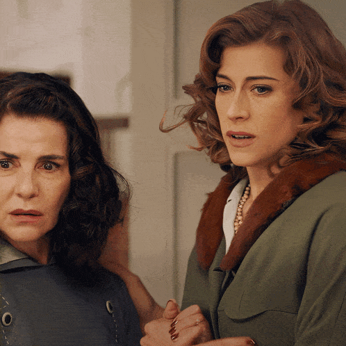 two women are standing next to each other and one has a fur collar