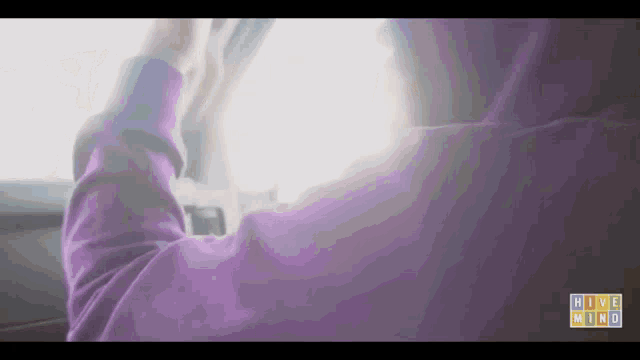 a person in a purple hoodie is driving a car with the words high wind on the bottom