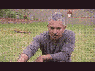 a man is stretching his arms in the grass