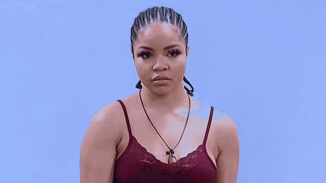 a woman wearing a red bra and a necklace looks down at something