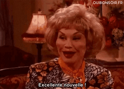 a woman sitting on a couch says excellente nouvelle in french