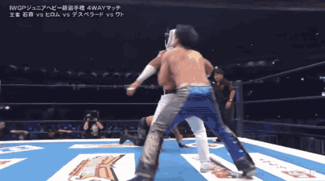two men are wrestling in a ring with chinese writing on the bottom right