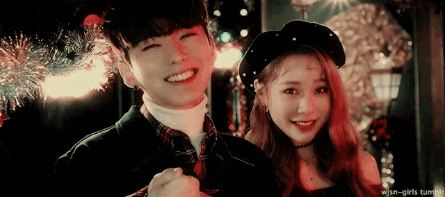 a boy and a girl are posing for a picture and the girl is wearing a hat