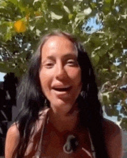 a woman in a bikini is smiling and looking at the camera .