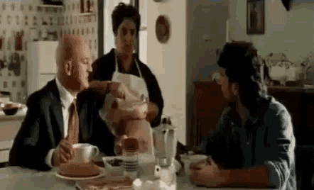 a man and a woman are sitting at a table talking to each other .