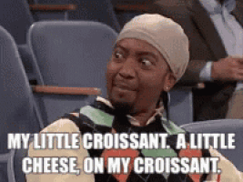 a man is sitting in a chair with a caption that says my little croissant