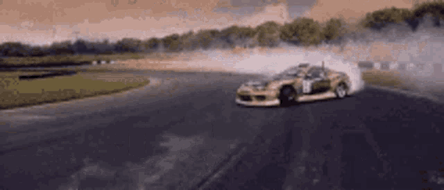 a car is drifting on a race track and smoke is coming out of the tires .