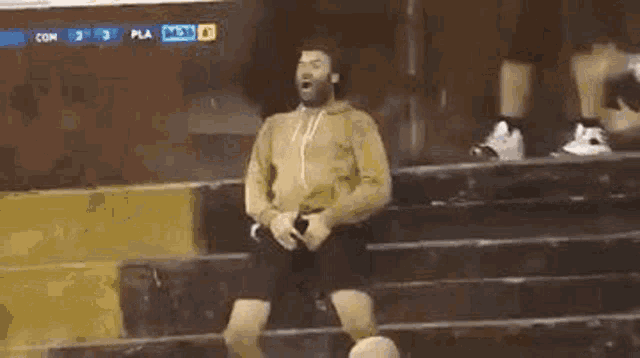 a man is standing on a set of stairs with a soccer ball in his hands .