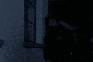 a man is wearing a headset and talking on a cell phone in a dark room .