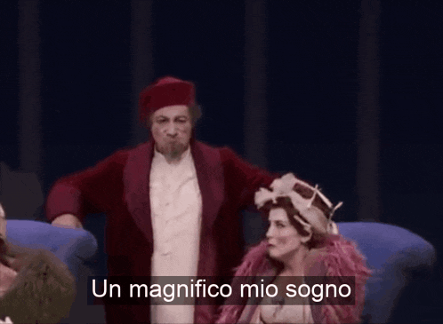 a man in a red coat stands in front of a screen that says un magnifico mio sogno
