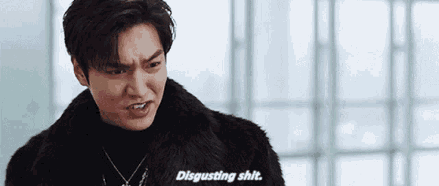 a man wearing a fur coat and a necklace is making a funny face and saying disgusting shit .