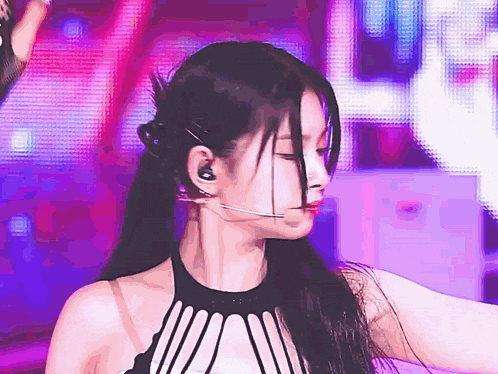 a close up of a woman wearing headphones and a microphone on a stage