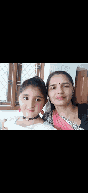 a woman and a little girl are posing for a picture .
