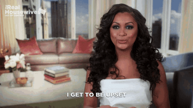 a woman says " i get to be upset " in front of a couch