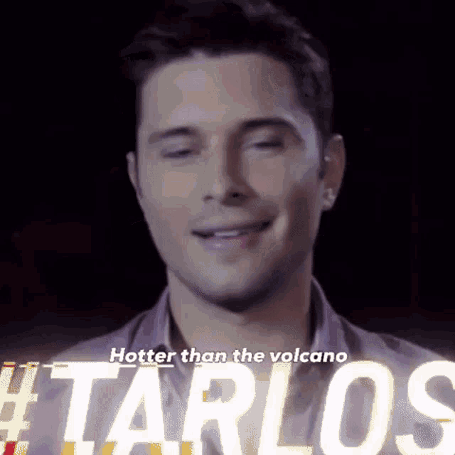 a man is smiling with the words hotter than the volcano #tarlos behind him