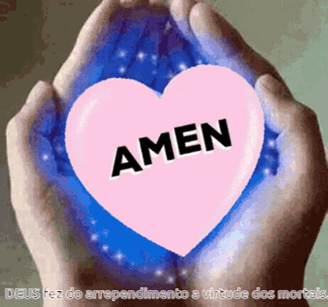 a person holding a pink heart with the word amen on it