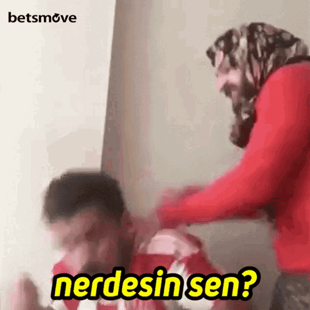 a woman in a red sweater is slapping a man in a red shirt and says nerdesin sen .