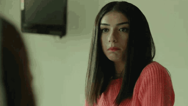 a woman in a red sweater is looking at another woman