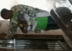 a man is doing push ups on a treadmill while wearing a green shirt .