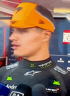 a man wearing a monster energy hat and a black shirt is talking to a reporter .