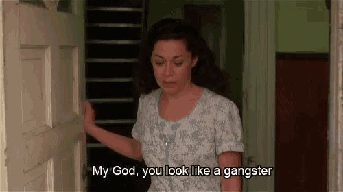 a woman says my god you look like a gangster while standing in a doorway