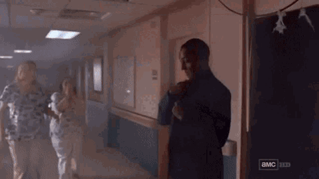 a man in a suit is holding a woman 's neck in a dark room .
