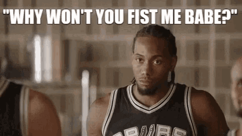 a basketball player in a spurs jersey is talking to another player in a gym .